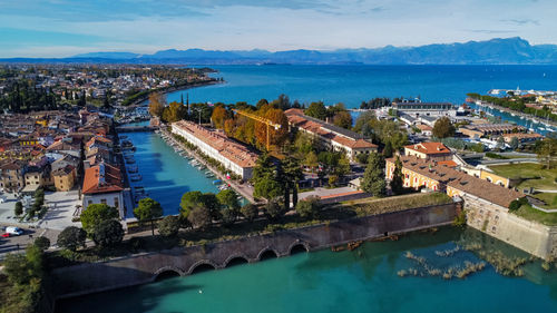 High angle view of city by sea against sky