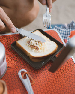 Cropped image of person with sandwich at table