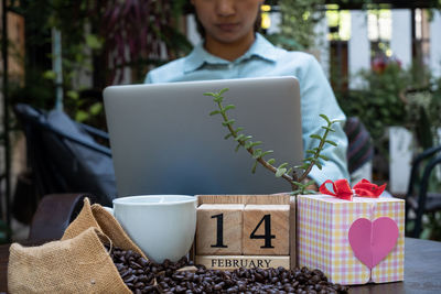 Midsection of woman using laptop at table with date