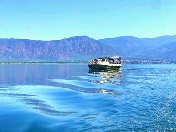 Scenic view of lake and mountains against blue sky