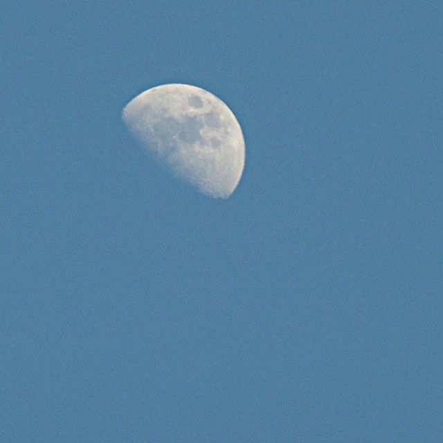 moon, low angle view, astronomy, copy space, beauty in nature, clear sky, full moon, scenics, nature, tranquility, blue, planetary moon, tranquil scene, sky, moon surface, space exploration, night, circle, sphere, majestic