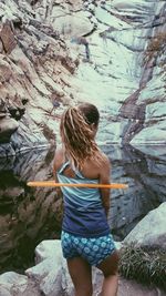 Rear view of woman standing on rock