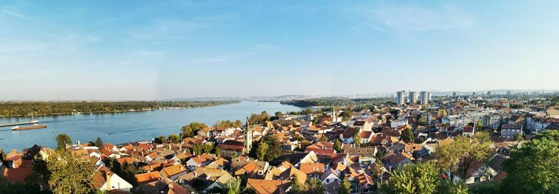 High angle view of townscape by sea against sky