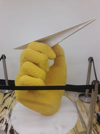 Close-up of yellow machine on table against wall
