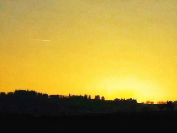 Silhouette landscape against clear sky during sunset