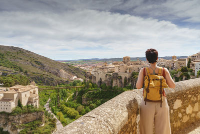 Rear view of woman looking at castle against sky