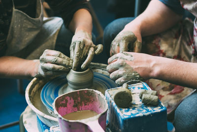 Midsection of potters making pottery