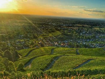 Aerial view of agricultural field against sky at sunset