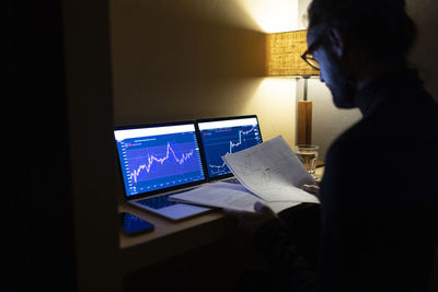 Working man reviewing documents late night in home office