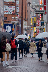 People walking on city street during rainy season