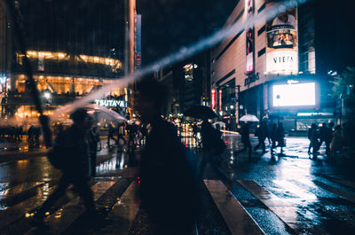 People walking on city street at night