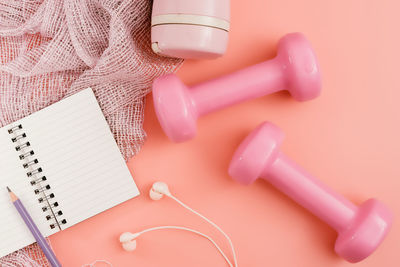 High angle view of dumbbells on pink background