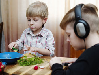 Portrait of boy holding camera on table