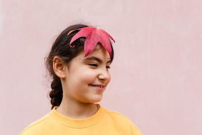 Smiling child with big red leaf in her hair