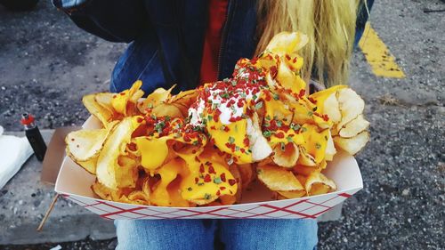 Midsection of woman with potato chips