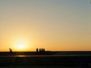 Silhouette people against sky during sunset