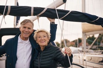 Portrait of smiling senior couple standing in yacht