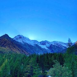 Scenic view of snowcapped mountains against clear blue sky