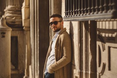 Portrait of handsome young man leaning on wall