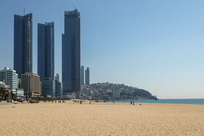 Panoramic view of beach and buildings against clear sky