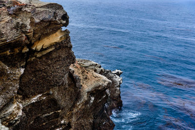 Rock formation in sea against sky