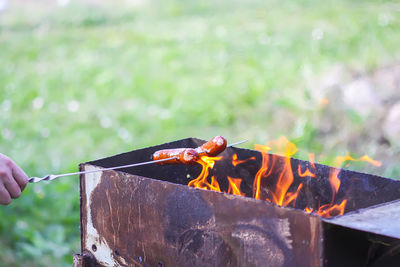 Cropped image of person preparing food on barbecue grill