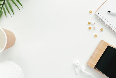 Office work, education flat lay with clips, phone, earphones, cup, tulip flowers on white background