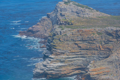 Steep cliffs and turquoise sea at the cape of good hope in south africa