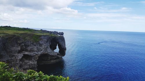 Rock formation in sea against sky