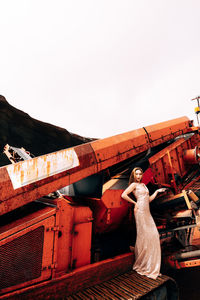 Rear view of woman standing by bridge against clear sky