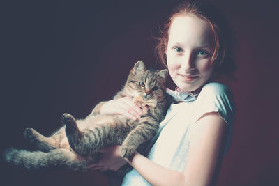 Portrait of girl holding cat