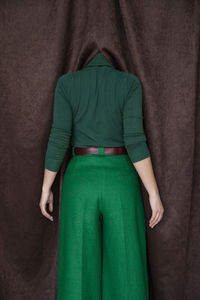 Woman hiding head behind curtain
