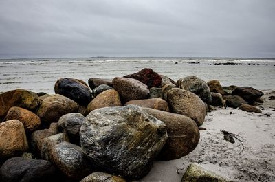 Rocks on beach against sky