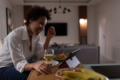 Young woman sitting on table at home