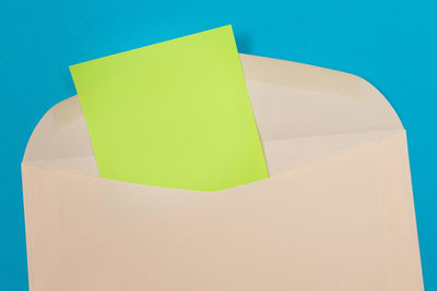 Close-up of yellow paper on blue table