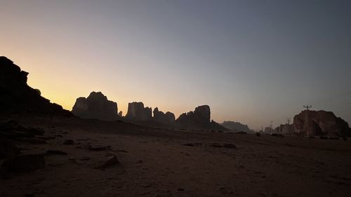 Rock formations on landscape against clear sky during sunset