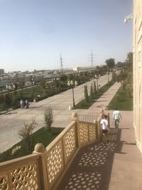 People on street by buildings against sky