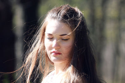 Close-up portrait of young woman with eyes closed