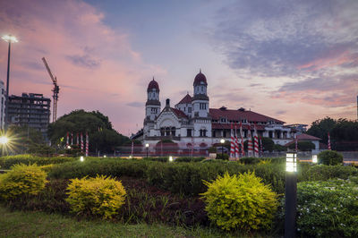 View of illuminated buildings against cloudy sky