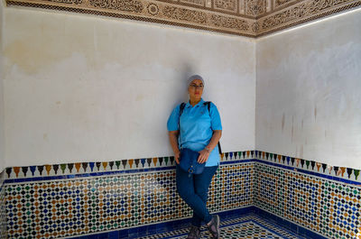 Portrait of young man standing against wall