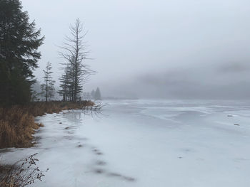 Scenic view of snow covered land against sky