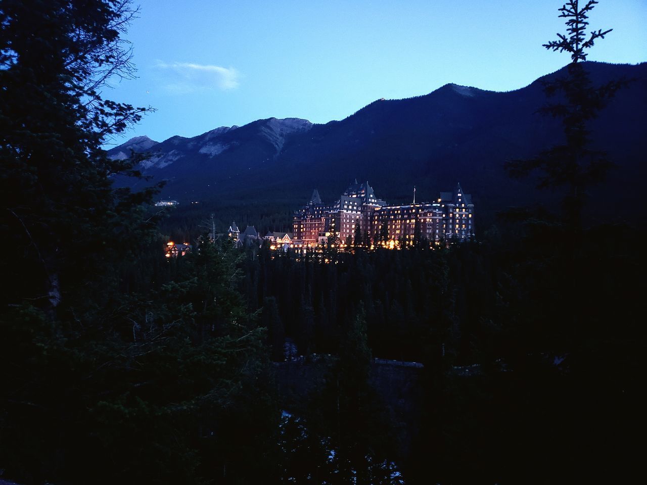 ILLUMINATED BUILDINGS IN CITY AT DUSK