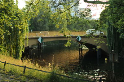 Footbridge over river against trees