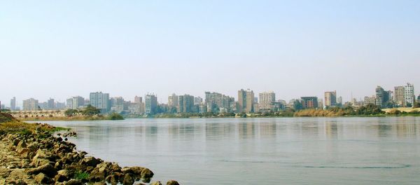 Scenic view of sea and buildings against clear sky