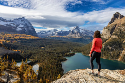 Rear view of woman looking at mountain against sky