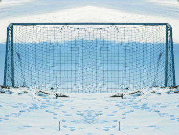 Scenic view of snow covered soccer field against sky