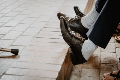 Low section of woman sitting on footpath