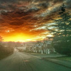 View of road against cloudy sky at sunset