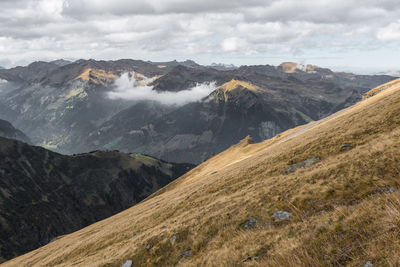 Scenic view of mountains against cloudy sky