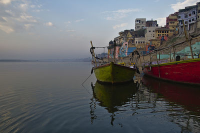 Fishing boat moored on sea against sky